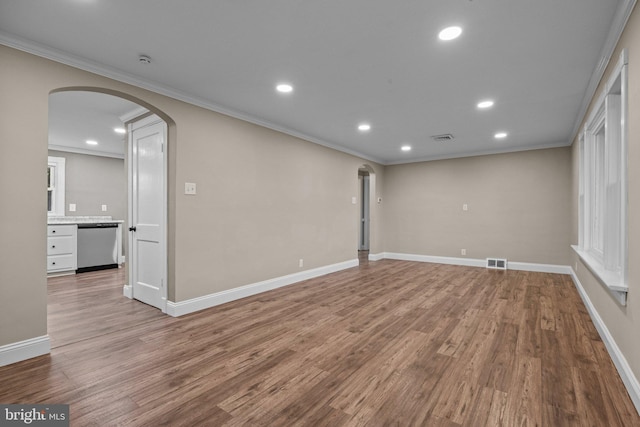 basement with visible vents, arched walkways, and wood finished floors