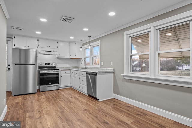 kitchen with under cabinet range hood, visible vents, appliances with stainless steel finishes, and a sink