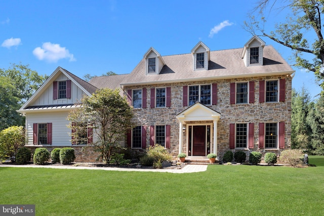 colonial home with stone siding, board and batten siding, a front lawn, and a standing seam roof