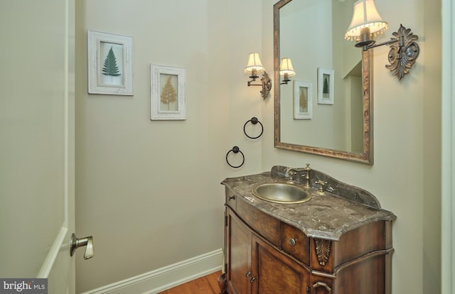 bathroom with baseboards, wood finished floors, and vanity