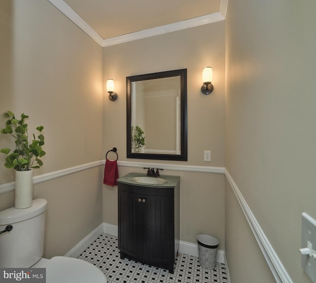 half bathroom featuring tile patterned floors, toilet, vanity, and crown molding