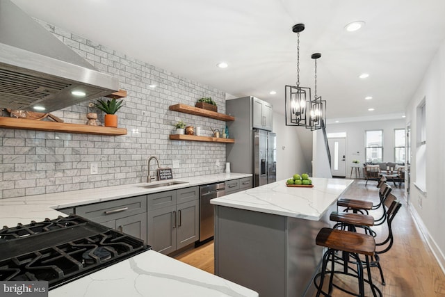 kitchen featuring open shelves, extractor fan, gray cabinets, stainless steel appliances, and a sink