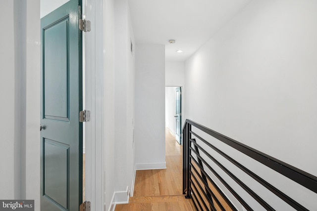 hall with baseboards and light wood-type flooring