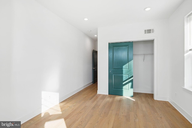 unfurnished bedroom with visible vents, wood finished floors, recessed lighting, a closet, and baseboards