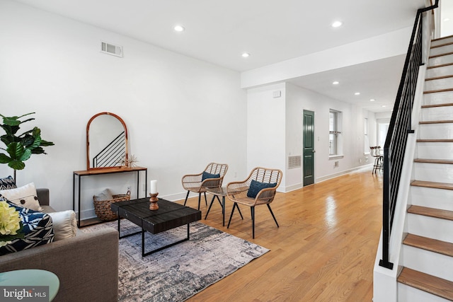 living area with stairs, recessed lighting, visible vents, and light wood finished floors