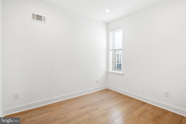 unfurnished room with visible vents, light wood-style flooring, and baseboards