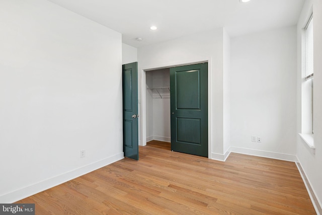 unfurnished bedroom with recessed lighting, a closet, baseboards, and light wood-style floors