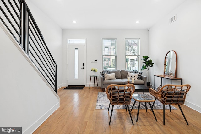 living area featuring visible vents, recessed lighting, light wood finished floors, baseboards, and stairs