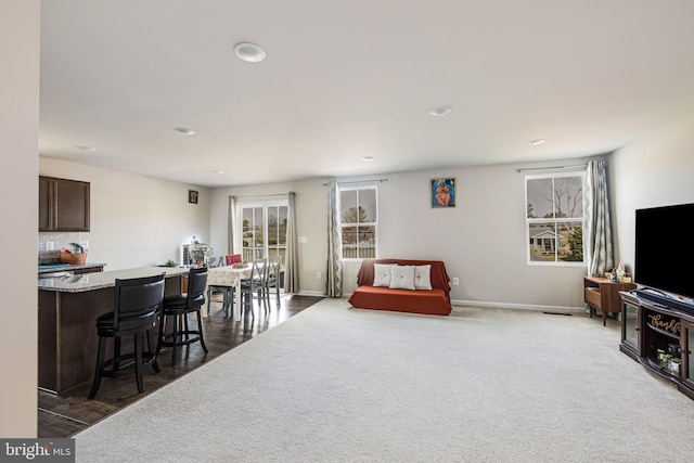 carpeted living area featuring recessed lighting and baseboards