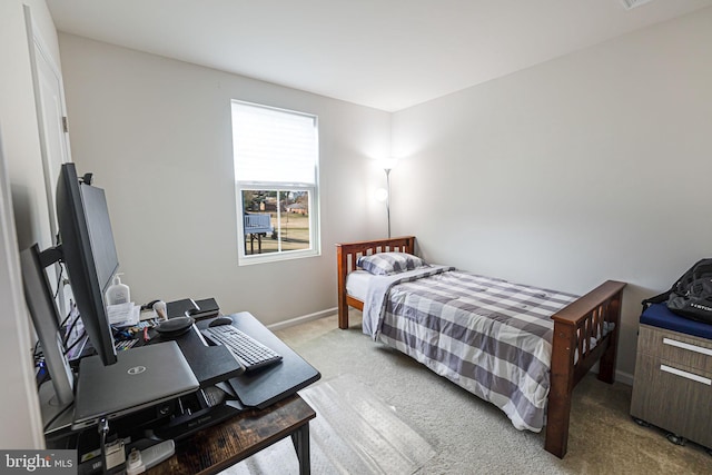 bedroom with light colored carpet and baseboards