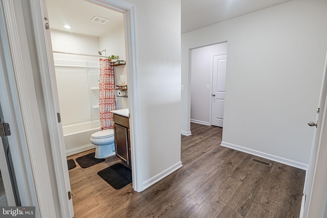 bathroom with visible vents, vanity, shower / tub combo, and wood finished floors