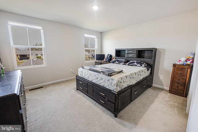 bedroom with light carpet, visible vents, and baseboards