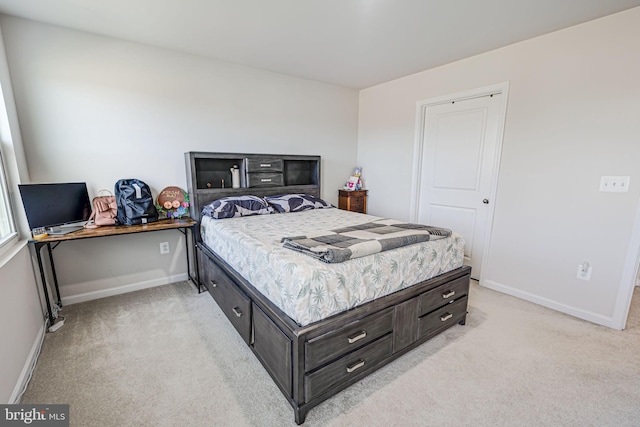 bedroom with baseboards and light colored carpet