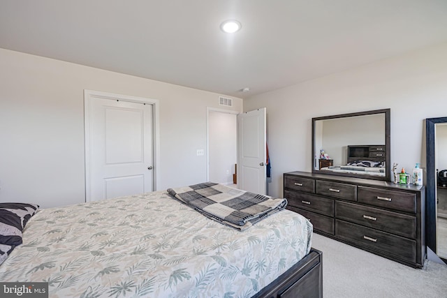 bedroom featuring visible vents and light carpet