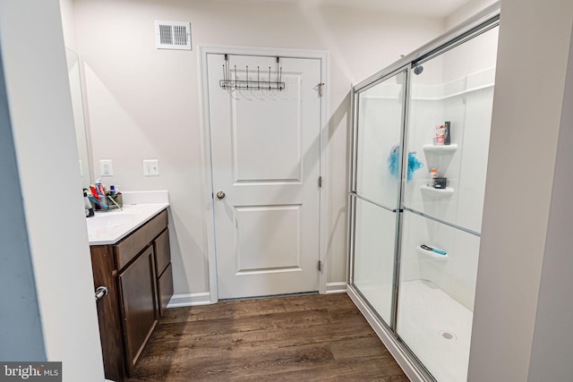 full bathroom with visible vents, a shower stall, vanity, and wood finished floors