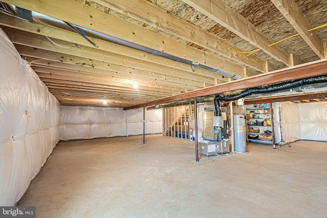 unfinished basement with stairway and electric water heater