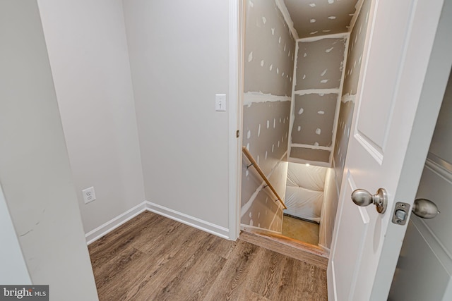 stairway featuring baseboards and wood finished floors