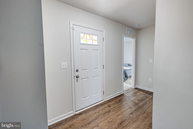 entryway with visible vents, baseboards, and wood finished floors