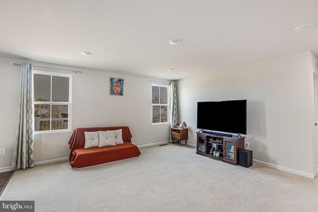 sitting room with baseboards, a healthy amount of sunlight, and carpet flooring