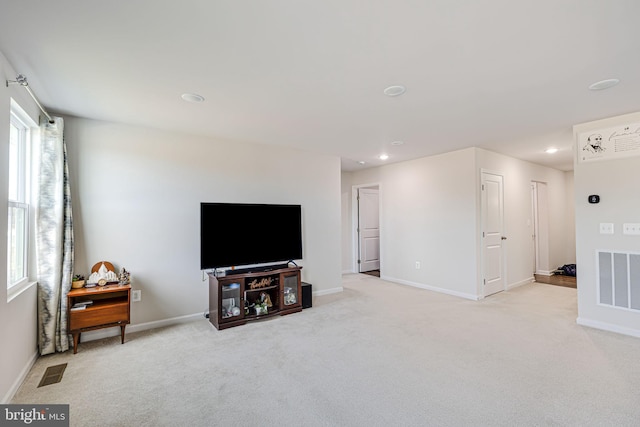 living room featuring visible vents, baseboards, and light colored carpet