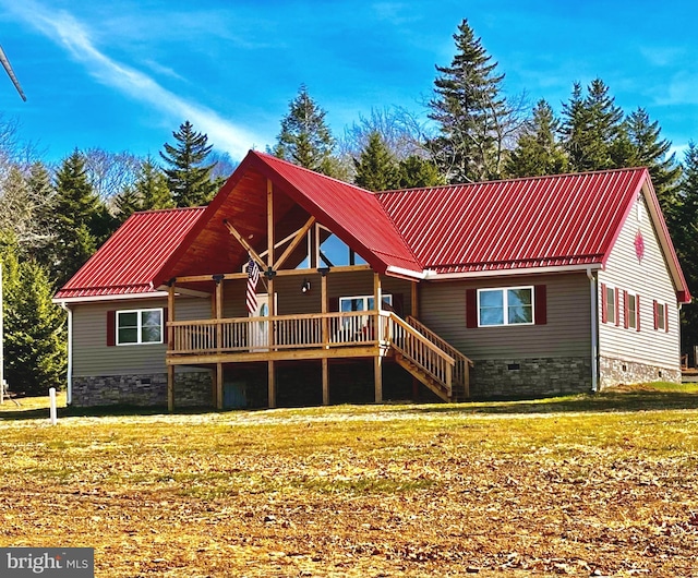 rear view of house with crawl space, a lawn, metal roof, and stairs