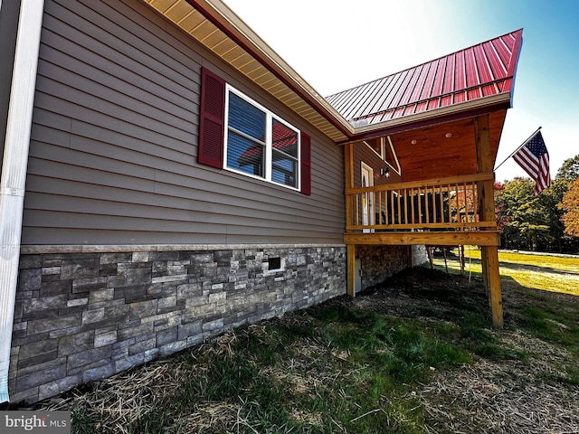 view of property exterior with a wooden deck and metal roof