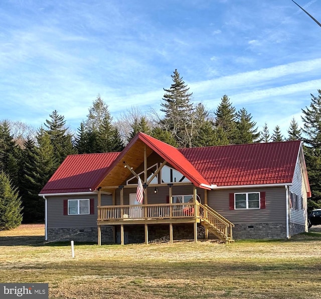 rear view of property featuring crawl space, a yard, and metal roof