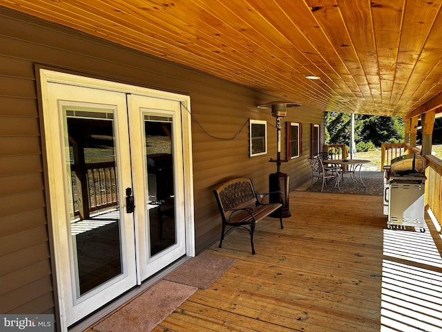 wooden terrace featuring french doors and outdoor dining space