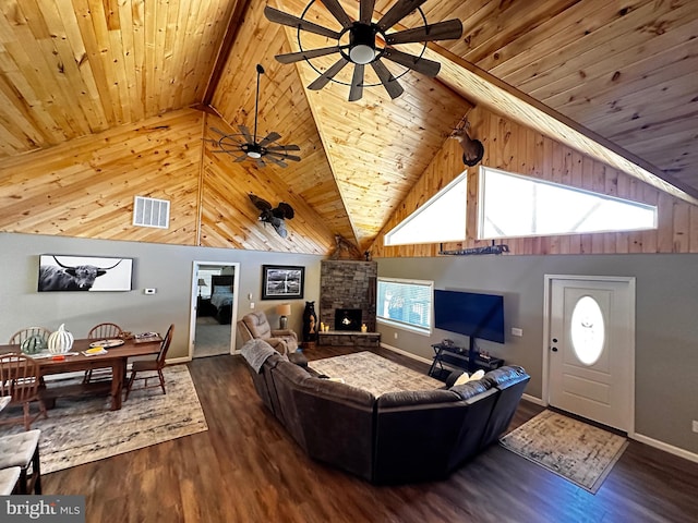 living area featuring visible vents, wood ceiling, beam ceiling, a fireplace, and wood finished floors