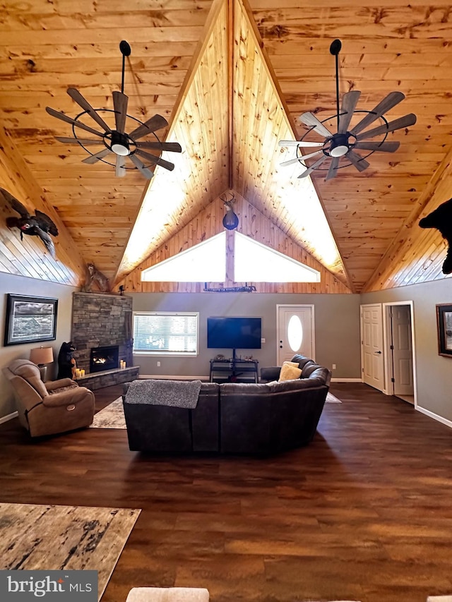 living area featuring a stone fireplace, wood finished floors, and ceiling fan