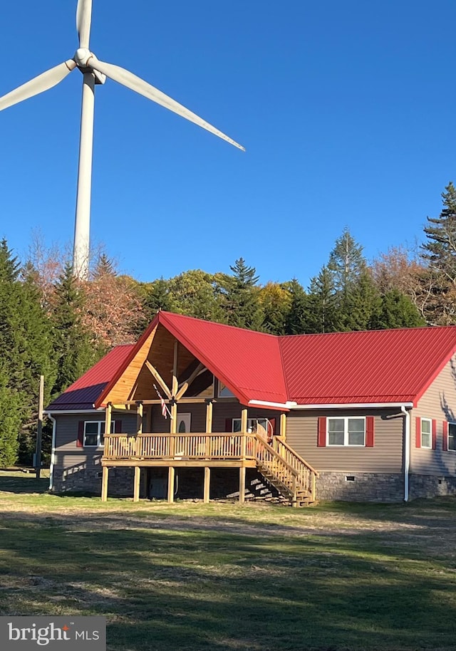 view of front of home with a front yard, stairway, crawl space, and metal roof