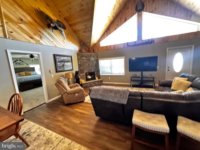 living room with baseboards, wood ceiling, vaulted ceiling, a fireplace, and wood finished floors