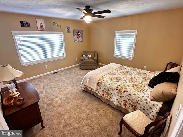 bedroom with visible vents, ceiling fan, baseboards, carpet floors, and a textured ceiling