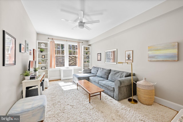 living area with carpet flooring, baseboards, radiator heating unit, and ceiling fan