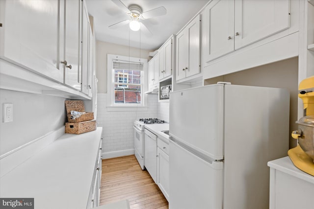 kitchen featuring white appliances, a ceiling fan, light countertops, light wood-style floors, and white cabinetry