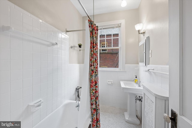 bathroom with tile patterned floors, shower / bath combination with curtain, tile walls, and wainscoting