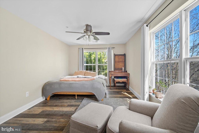 bedroom featuring ceiling fan, baseboards, and wood finished floors