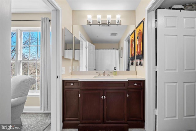 full bathroom featuring a notable chandelier, curtained shower, vanity, and baseboards