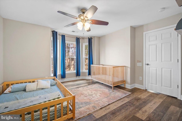 bedroom with visible vents, ceiling fan, baseboards, and wood finished floors