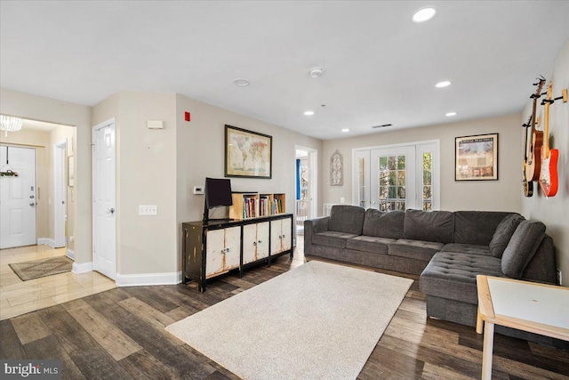 living area with recessed lighting, visible vents, baseboards, and wood finished floors