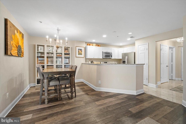 dining space featuring recessed lighting, baseboards, wood finished floors, and a chandelier