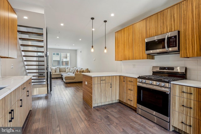 kitchen featuring a peninsula, dark wood-style floors, modern cabinets, and stainless steel appliances