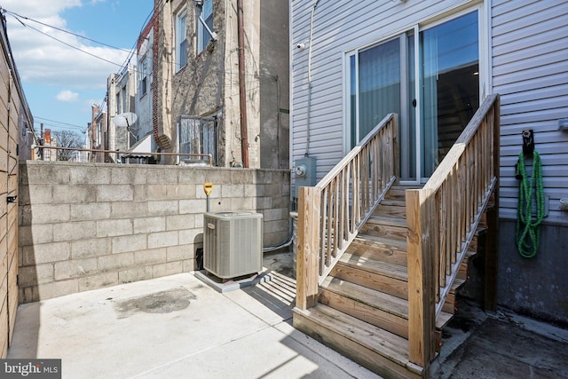 entrance to property featuring central air condition unit and a patio