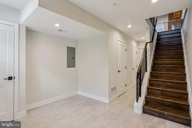 stairs with electric panel, visible vents, and recessed lighting