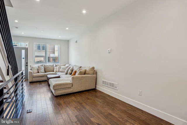 living area with recessed lighting, visible vents, baseboards, and dark wood finished floors