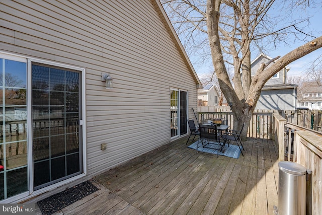 deck featuring outdoor dining area and fence