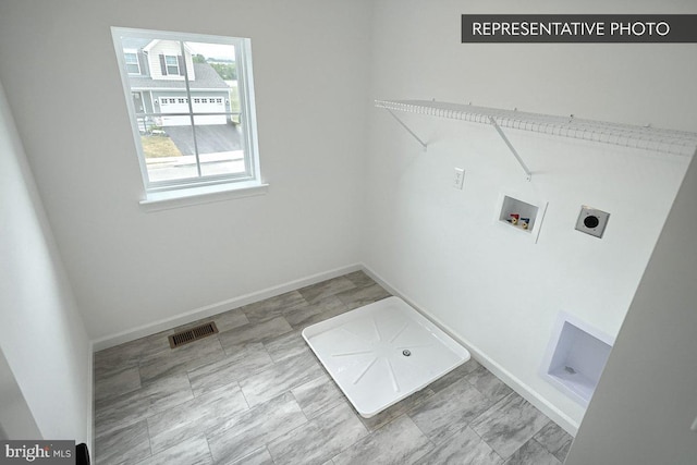 clothes washing area featuring electric dryer hookup, visible vents, baseboards, hookup for a washing machine, and laundry area