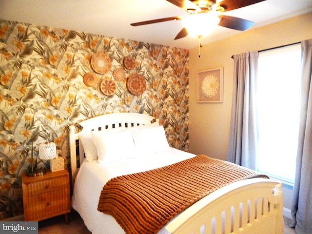 bedroom with wallpapered walls and ceiling fan