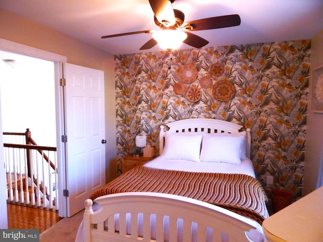 bedroom with ceiling fan and wallpapered walls