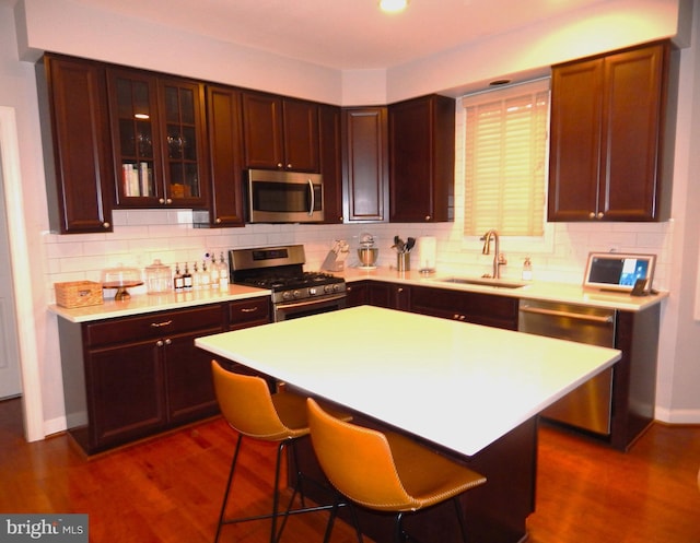 kitchen featuring a sink, stainless steel appliances, tasteful backsplash, and light countertops